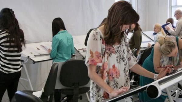 Photo of a woman working at an angled desk