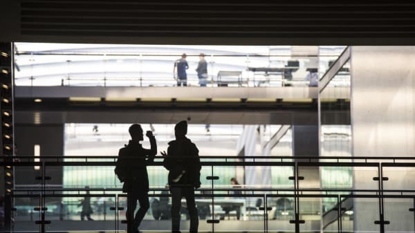 Silhouette of two people standing on a walkway