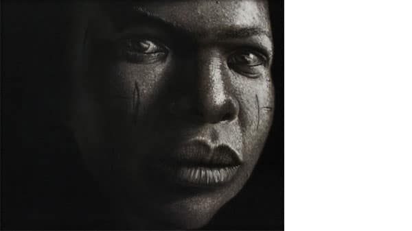 A close up of a face with scarification