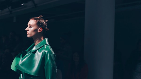 Model with hair in bunches and wearing a Marta Jakubowski coat, on the catwalk
