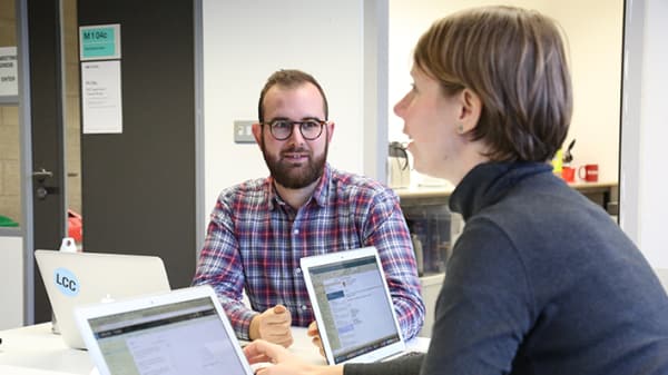 Photograph of students working on laptops at desks within the Graduate School Space at London College of Communication.