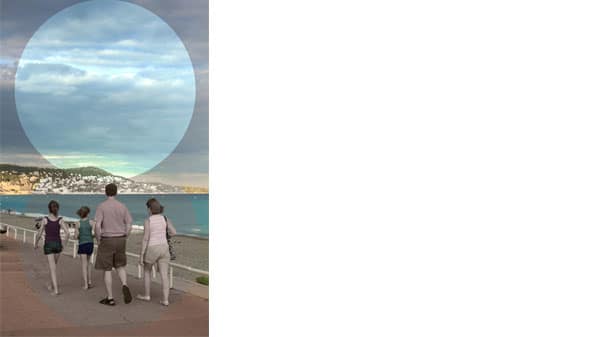 Four people walking alongside the sea with a cut out circle above