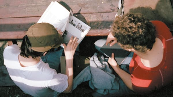 Two students reading reference books