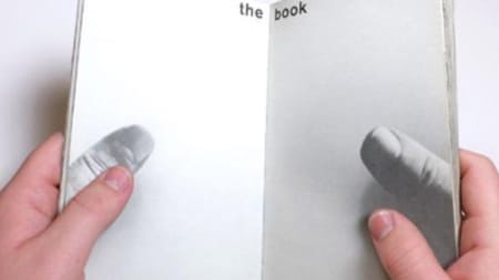 A pair of hands holding a book open