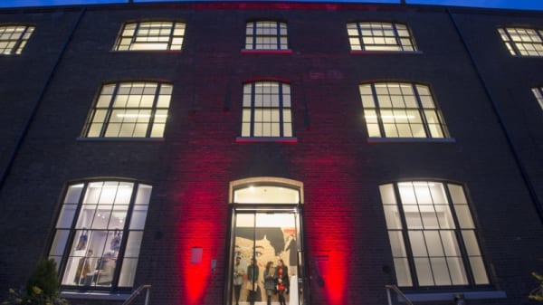 Photograph taken at night which looks up at a large brick building