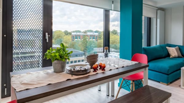 Photo of a living and dining area at Gardens House with a dining table and sofa