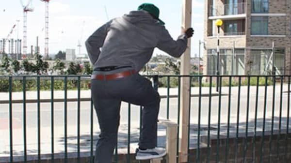 Man climbing over a fence