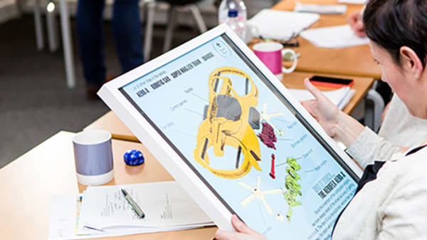 Someone engaging with a student design mock-up on an Ipad screen.