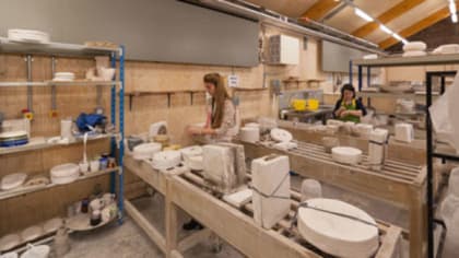 Students working with clay and ceramic pieces on display inside the Ceramics Workshop at Central Saint Martins