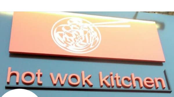 An orange sign that says 'Hot Wok Kitchen'