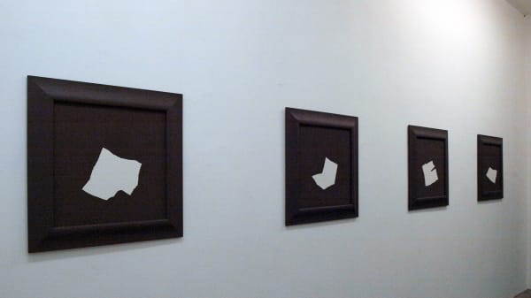 Four black-and-white canvases on a wall