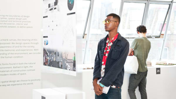An LCC student looks at a piece of digital work during a degree show exhibition.