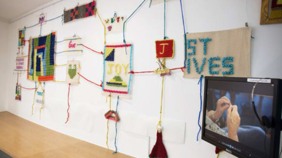 A series of knitted pieces hung on a waal
