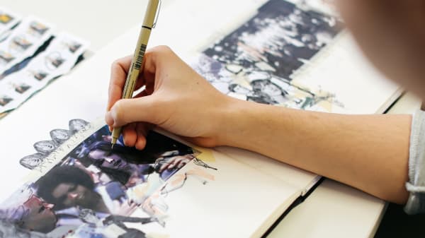 Close up shot of someone drawing on magazine pictures with a pen