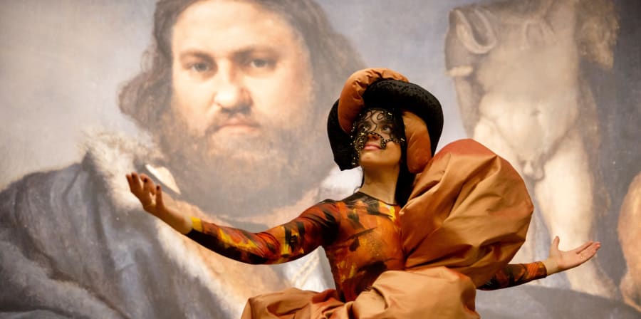 Performer wearing costume in front of painting