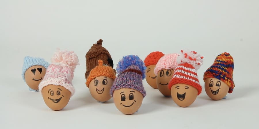 A still of eggs with smiles and bobble hats.