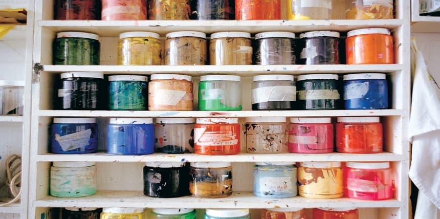 Shelves of coloured paint pots