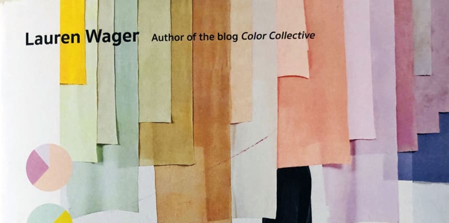 A single figure walks across a gallery space filled with hanging colour banners.