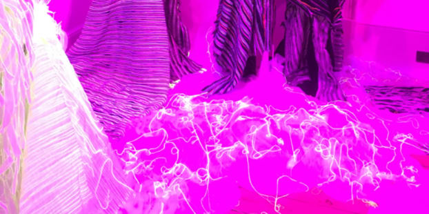 clear mannequins in a brightly lit, pink neon coloured room