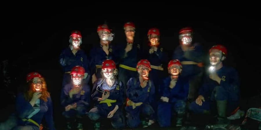 A group of students wearing hard hats and overalls