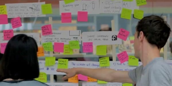Students using colourful post-it notes to map out ideas for the design of a petition for Plan International UK.