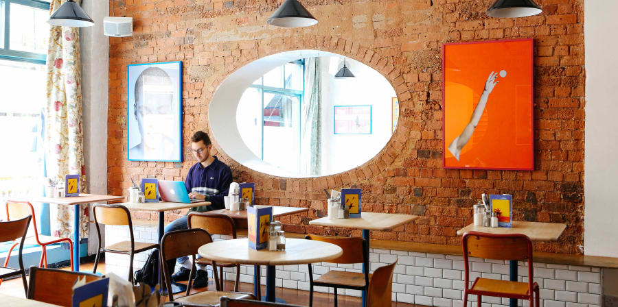 Student working on a laptop in a coffee shop