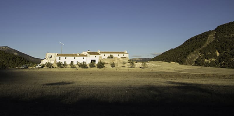 Photo of a large white house in between two hills