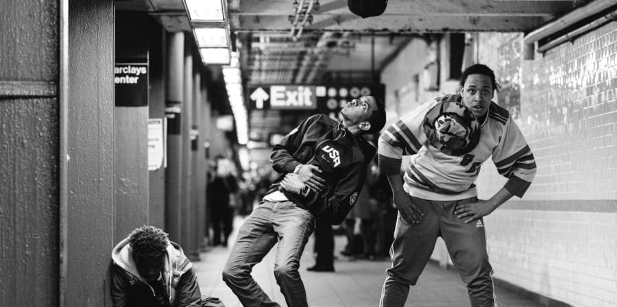 3 male street dancers doing a performance on the subway
