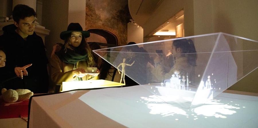 Visitors watch a hologram of student work.