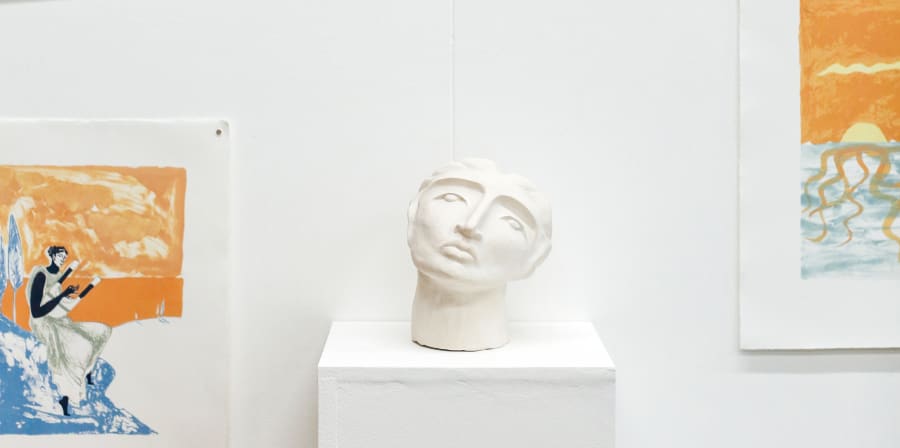 Display of a sculpture of a face and drawings
