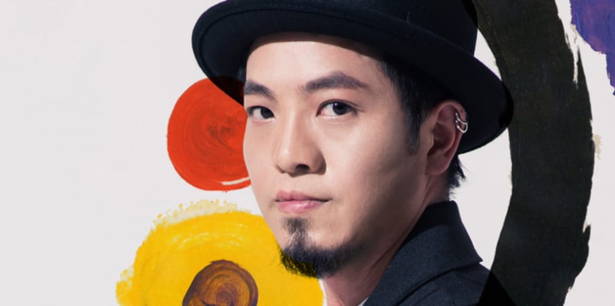 Portrait photo of a man in a bowler hat, looking to camera, with painted circles