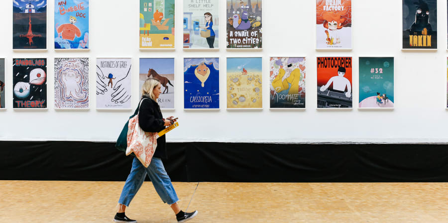 Student walking along a corridor with animated posters on the wall