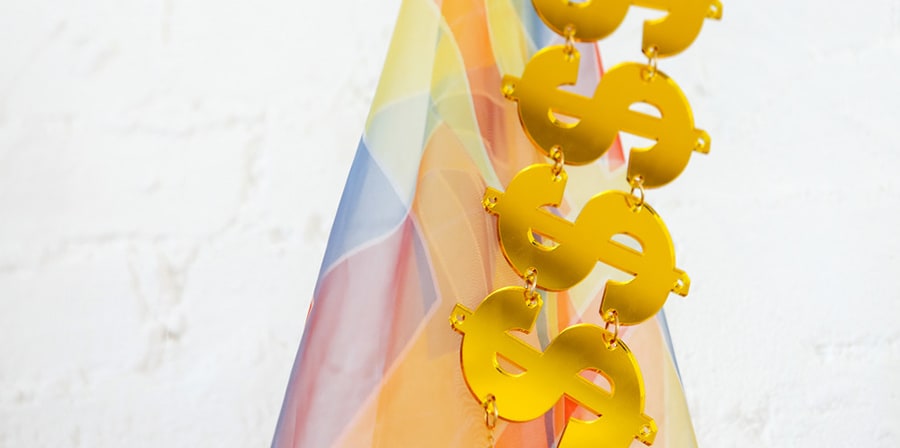 Multicoloured material with metal dollar signs hanging vertically down.