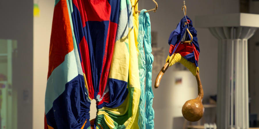 Image of colourful clothing exhibited in a gallery
