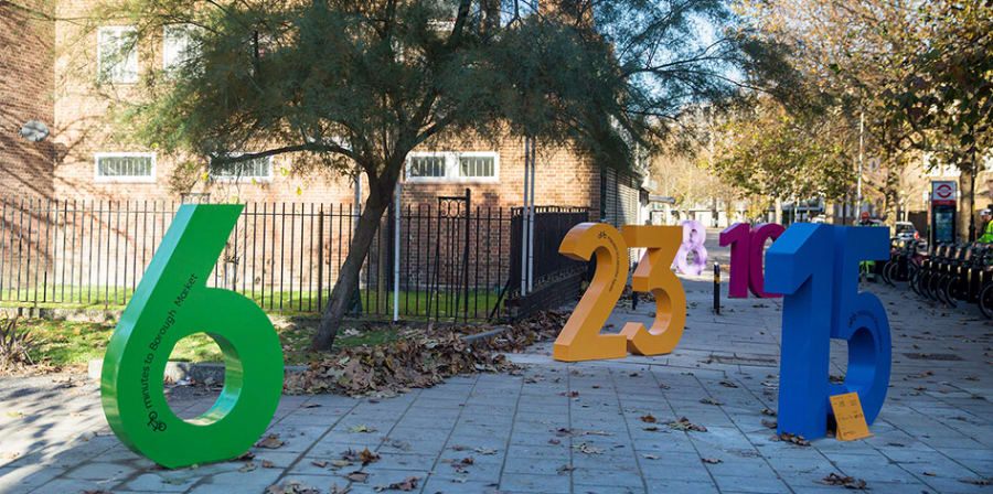 An installation of large colourful numbers designed by LCC graduates and placed around the Santander Cycle Hire docking station.