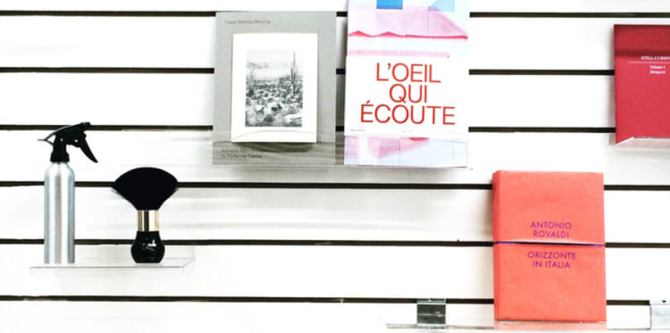 Items are placed on shelves in front of a black and white striped wall.