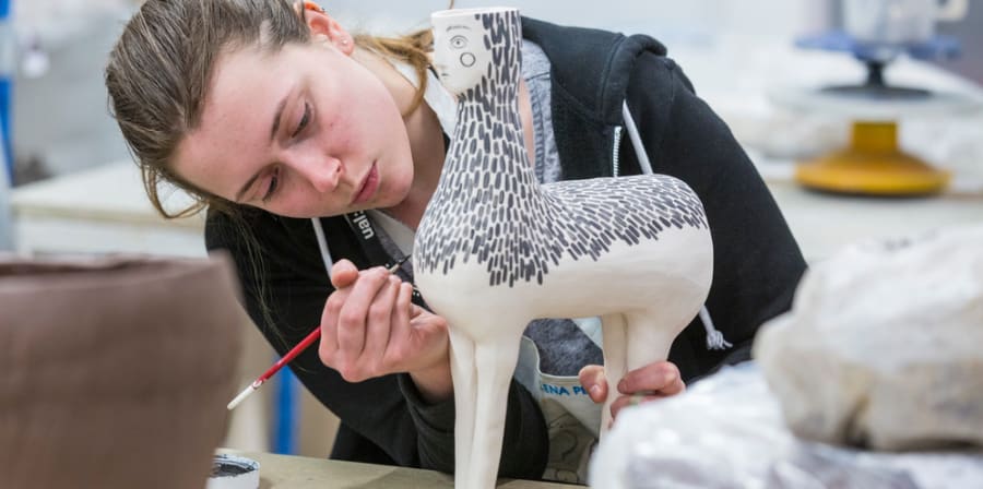 Student working on ceramics design in a workshop space