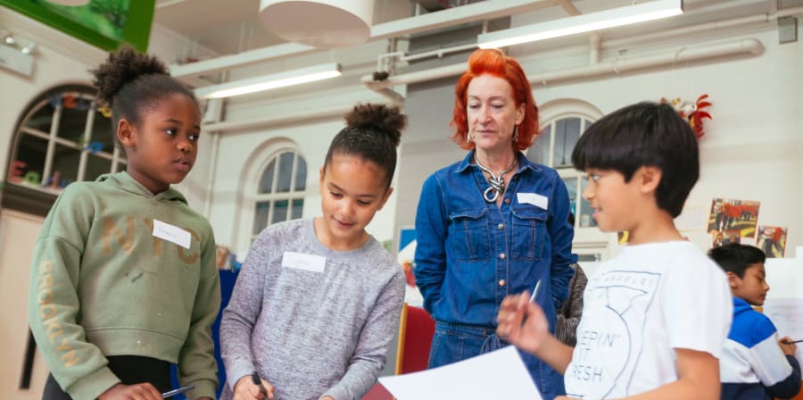 A tutor supervising three young students