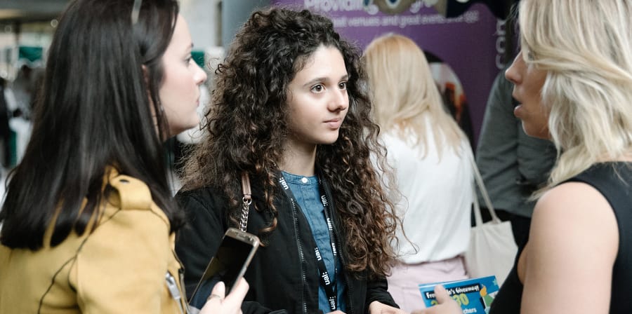 Photo of an employer talking to two students