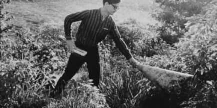 man cutting grass in a black and white