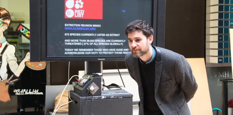 man speaking in front of a screen