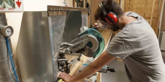 A student cutting wood with a circular saw 