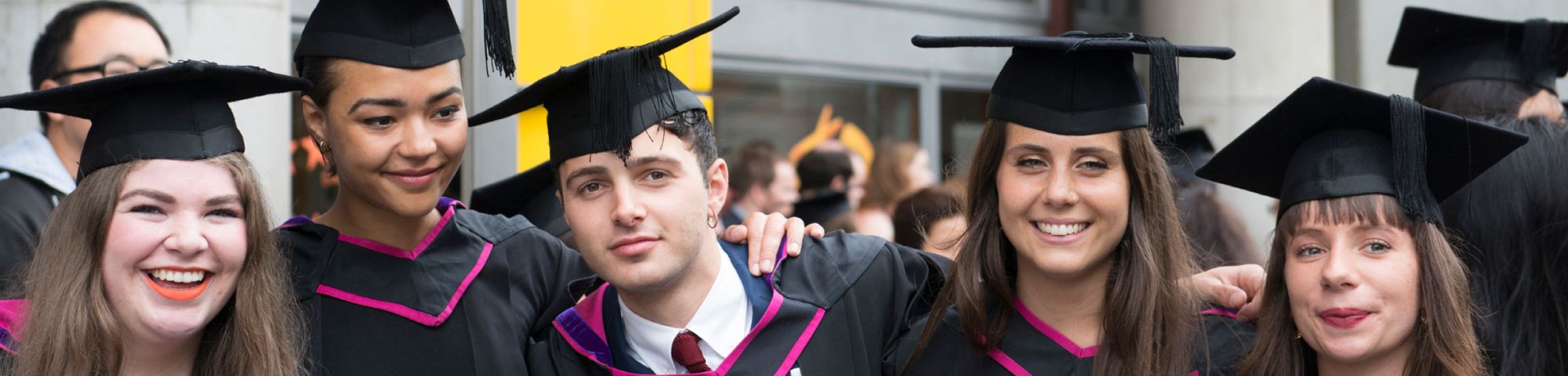 A group of students wearing graduation robes and mortarboard caps after graduating from University of the Arts London UAL