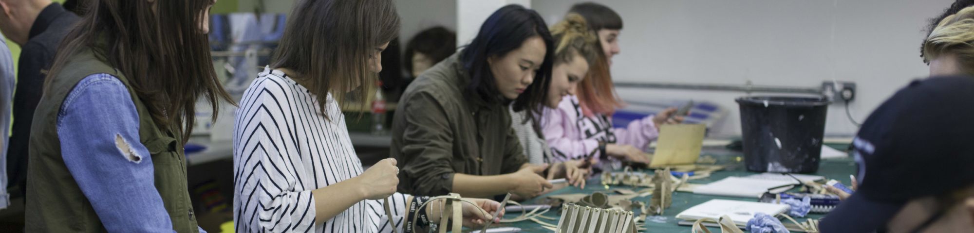 Students at a workbench using materials to create models