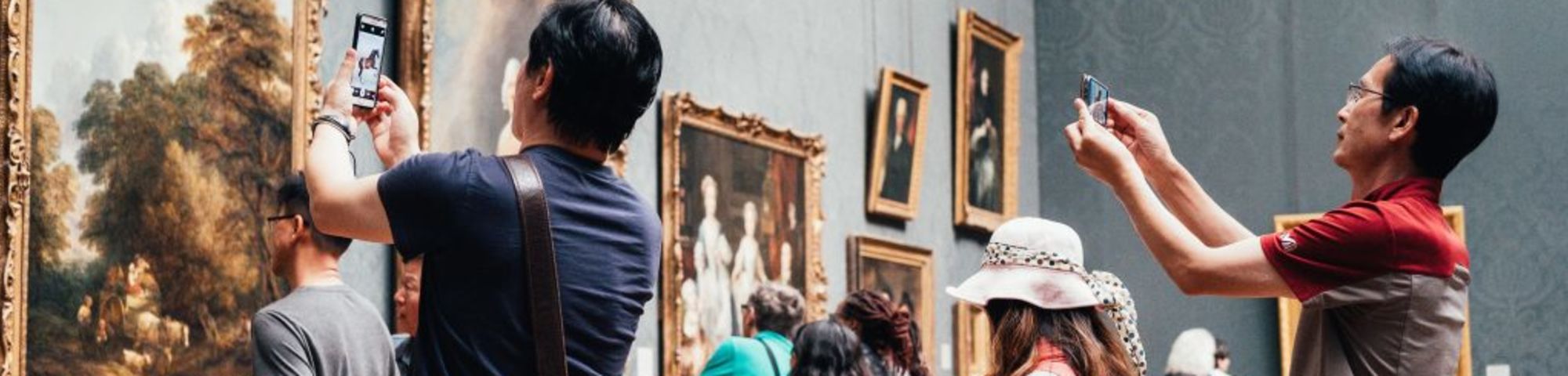 people photographing a painting in a museum