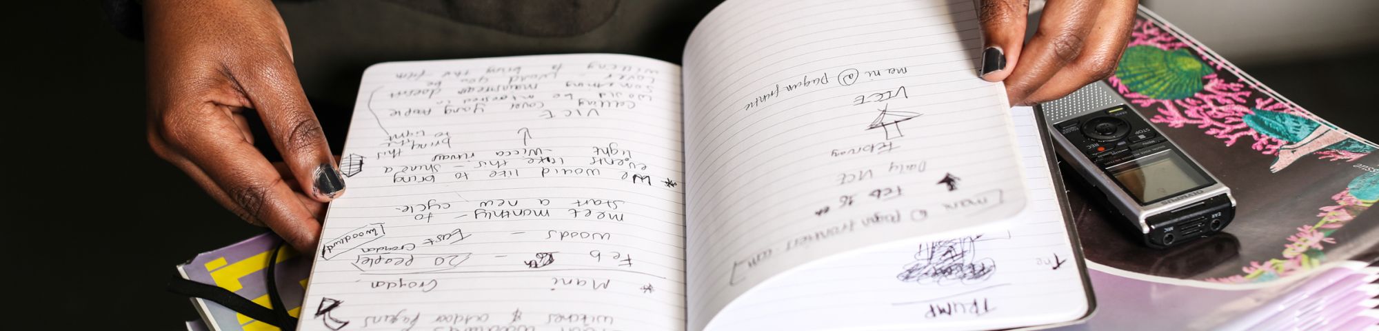 Hands leafing through a notebook