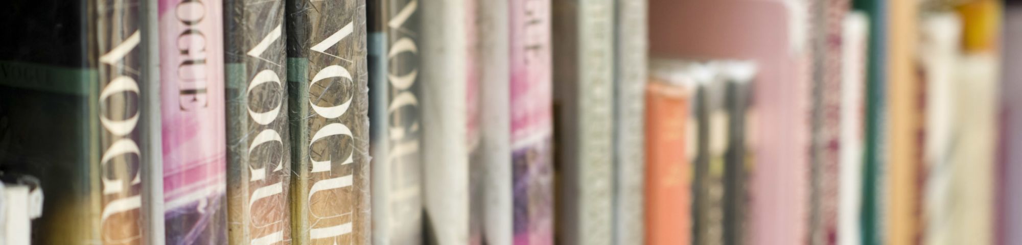Side view of a collection of Vogue magazines on a bookshelf