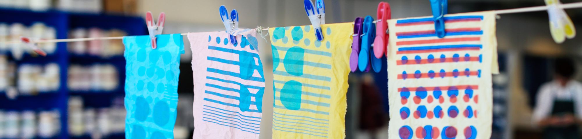 Pieces of paper with colourful patterns on hanging on a line