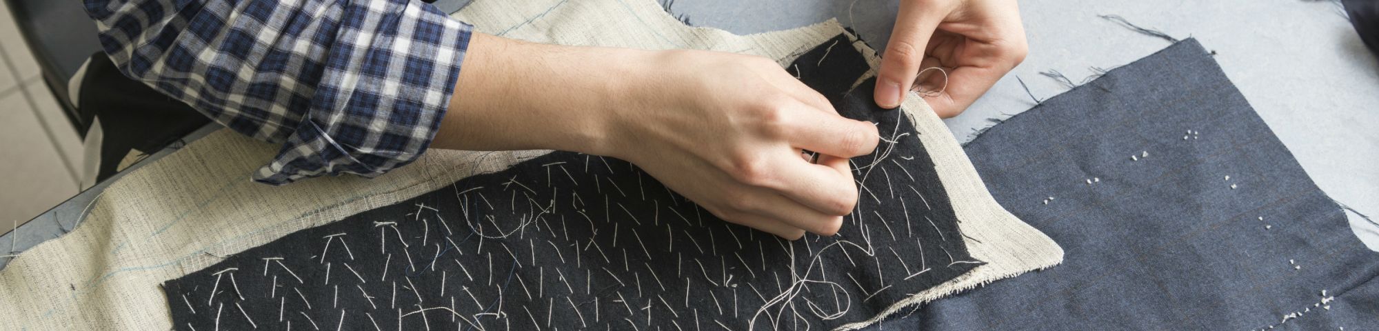 Student working on pattern cutting with dark grey material