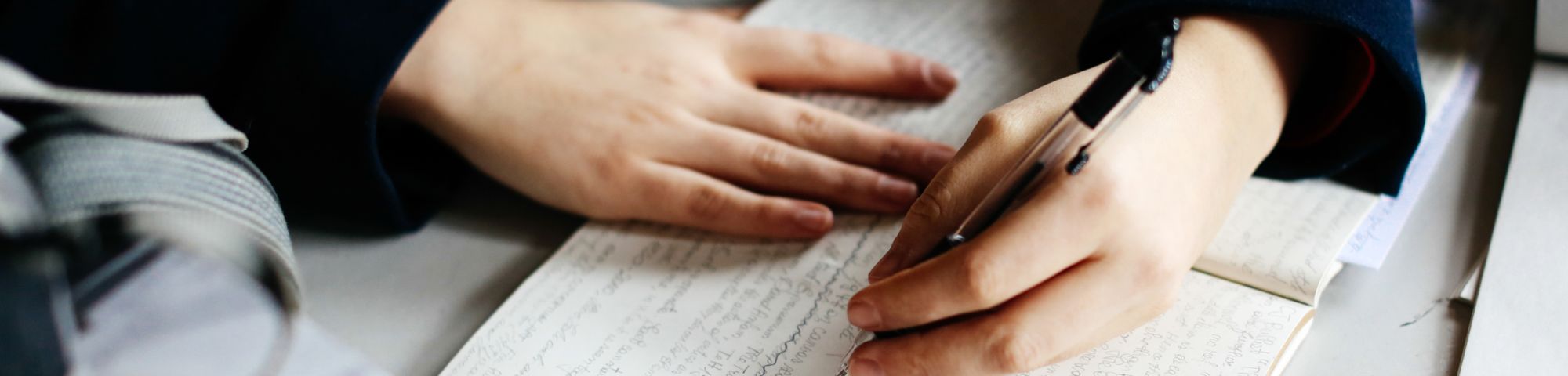 Hands writing in a notebook